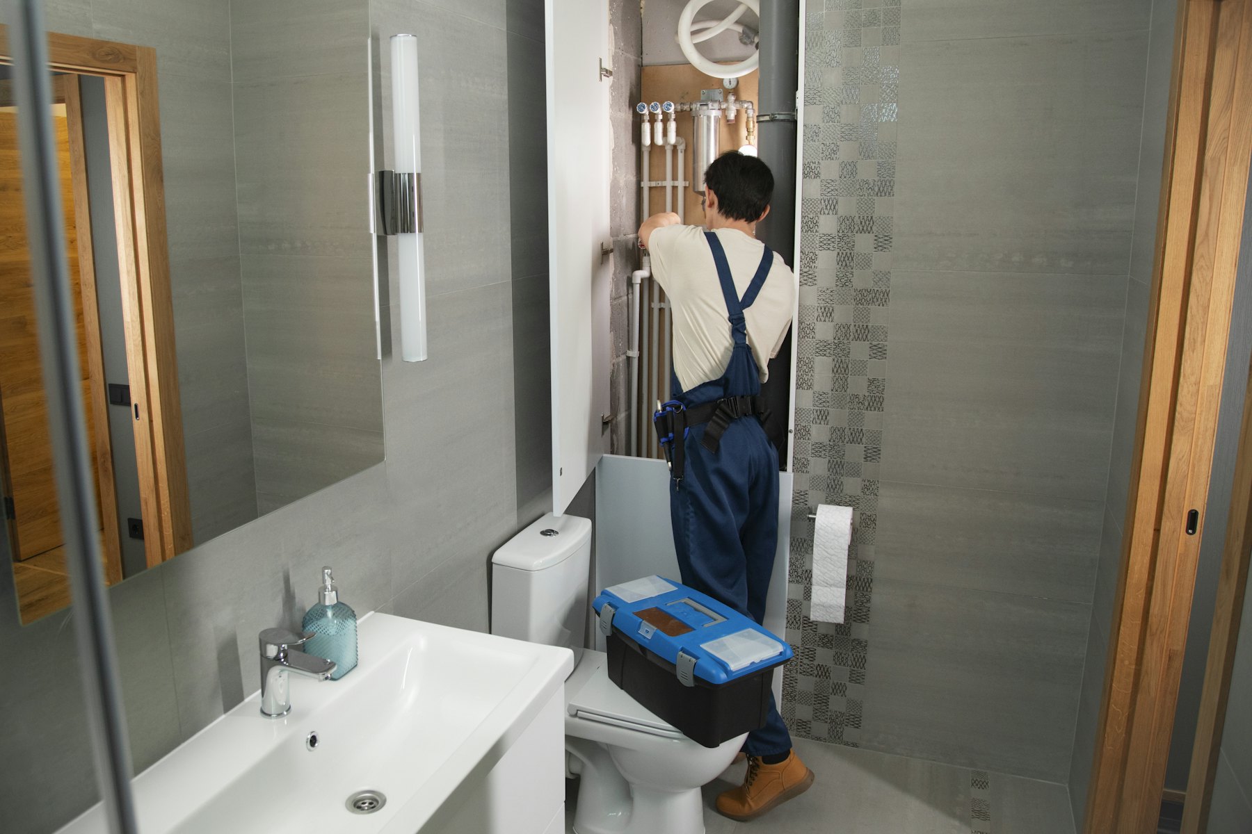 A plumber working in a bathroom (illustrative stock photo)